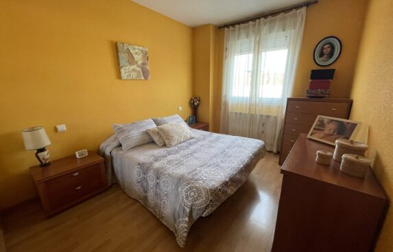 Venta y alquiler pisos en Zamora, inmobiliaria EMYR. Dormitorio con cama grande central, dos mesillas pequeñas y una grande.