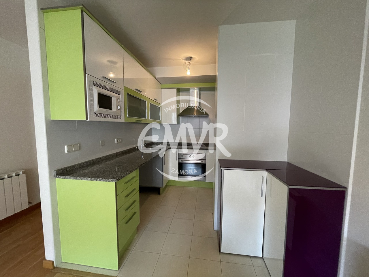 Venta y alquiler pisos en Zamora, inmobiliaria EMYR. Cocina en blanco y verde lima con campana extractora y horno en inox.